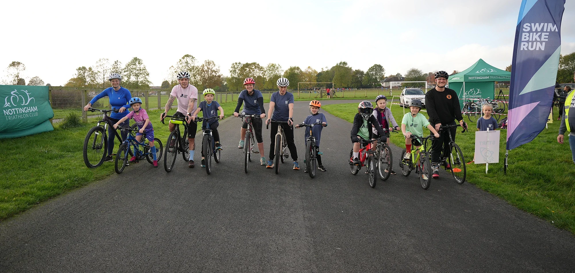 A group of adults and children posing before starting a bike ride