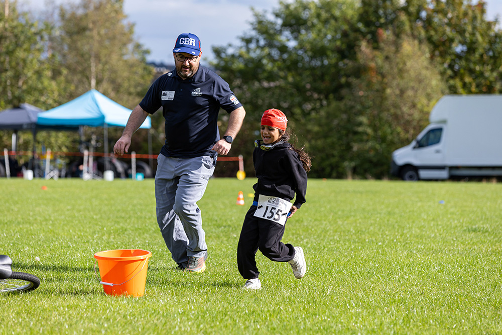 A volunteer running with a child, playing a game