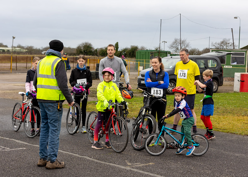 A group of adults and children getting ready for a bike ride